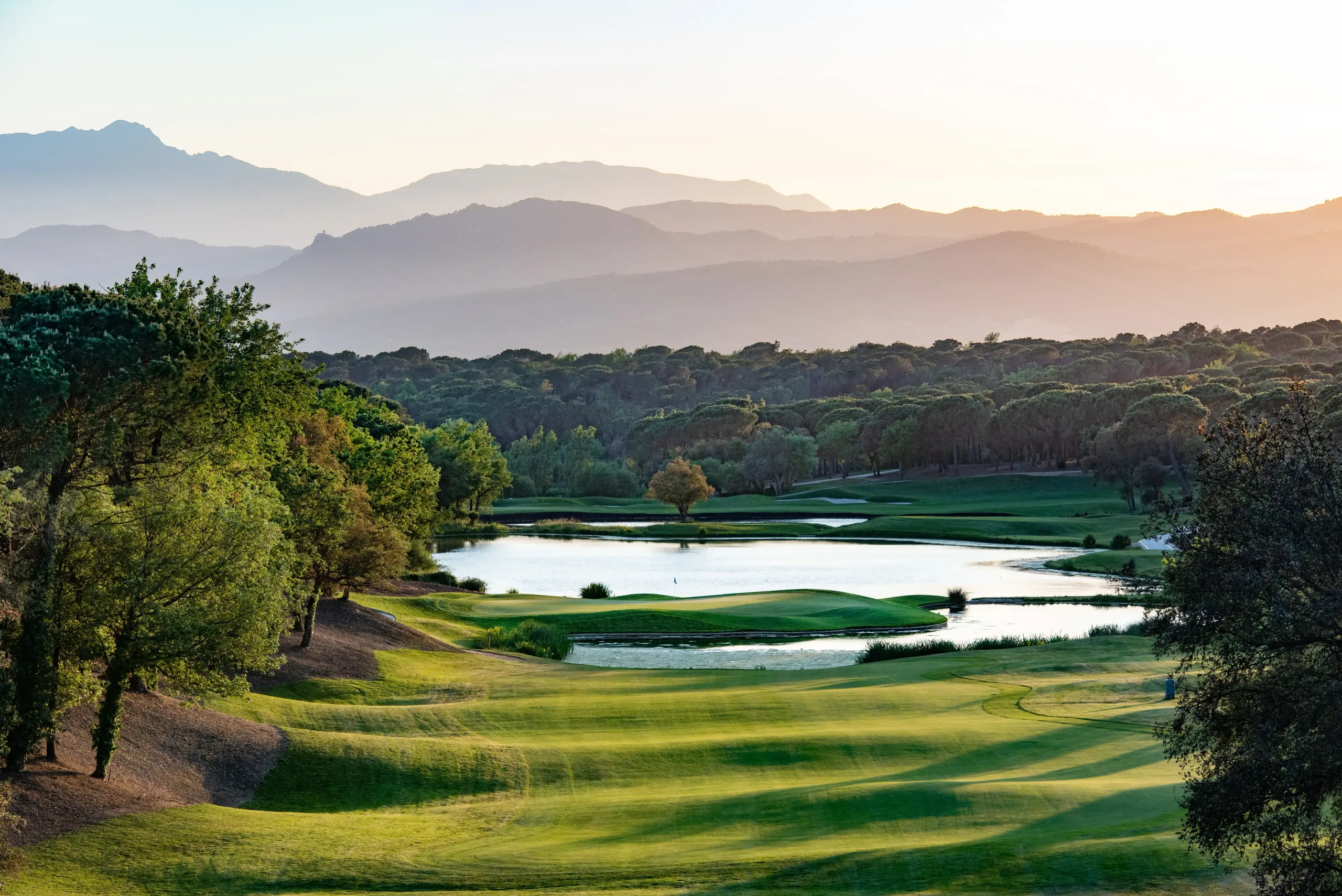 The scenic golf of Camiral with forests and mountains in the background