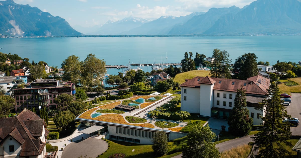 Drone view of Clinique La Prairie in Montreux with Lake Geneva in the background and the Alps