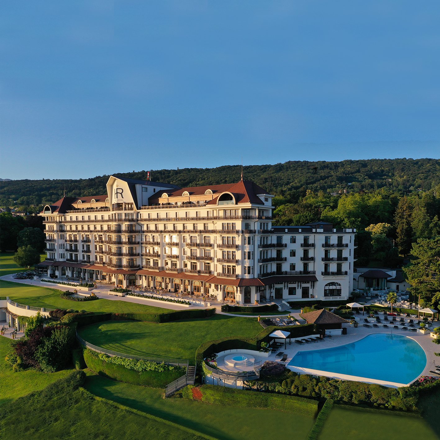 Aerial view of the Hôtel Royal Evian Palace hotel with pool and grounds overlooking Lake Geneva
